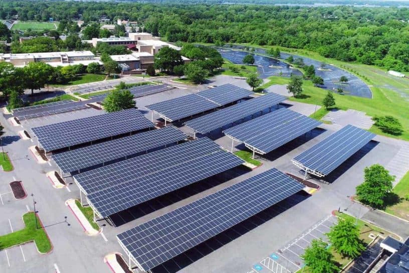 Aerial view of a parking lot covered with rows of solar panels, harnessing renewable energy while providing shade for parked cars below.