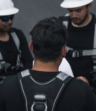 A team of construction workers in safety gear engaging in a discussion on a work site.