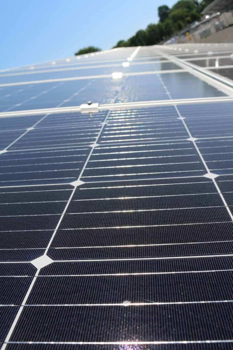 Rows of solar panels under a clear blue sky, harnessing the sun’s energy.